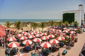 大洋城沙中城堡酒店的海滩上一组红色和白色遮阳伞的桌子