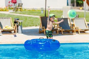 乔尔蓬阿塔东灵卡酒店的在一个游泳池里玩耍的一个男孩