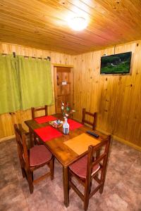 伊瓜苏港卡瓦尼亚斯山林小屋的木制用餐室配有桌椅