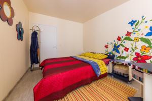 塔林城市中心花园露营地的一间卧室配有一张带红色和黄色毯子的床