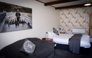 格林坦纳格林坦纳公园中心的酒店客房,配有床、沙发和绘画作品