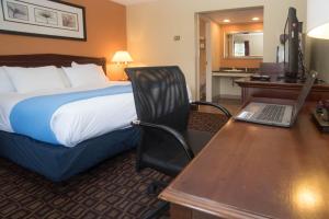 Lyndonville柱廊旅馆的酒店客房配有一张床、一张书桌和一台笔记本电脑
