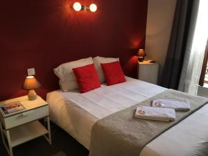 迪南剧院餐厅酒店的一间卧室配有一张带红色枕头的大床