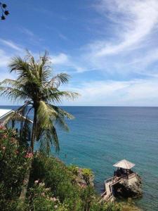 沙璜安诺伊艾塔姆度假酒店的海边的棕榈树,带桌子和雨伞