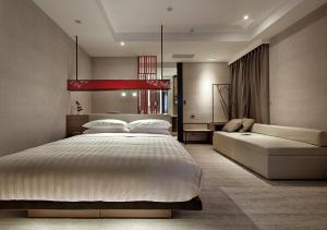台南文悦旅栈的一间卧室配有一张大床和一张沙发