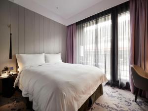 台北天云旅栈台北基河馆的卧室设有一张白色大床和大窗户