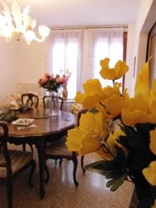 威尼斯伊克斯克鲁西弗食宿酒店的用餐室配有桌子和黄色鲜花