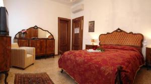 威尼斯伊克斯克鲁西弗食宿酒店的一间卧室配有一张红色的大床和一把椅子