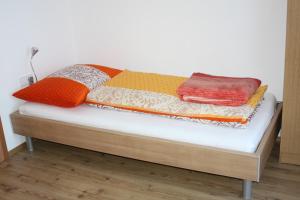 蓬高圣约翰霍尔斯勒恩沃夫公寓的床上配有色彩缤纷的毯子和枕头