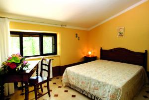 Rocca dʼEvandroIl Nibbio Reale Country House的一间卧室配有一张床、一张桌子和一张桌子