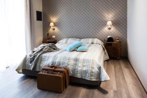 莫利亚诺威尼托阿拉麦塔住宿加早餐旅馆的一间卧室配有一张带蓝色枕头的床和行李箱