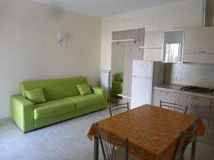 维耶斯泰Appartamento Bilocale a 200 m dalla spiaggia的客厅配有绿色沙发和桌子