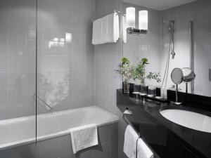 维也纳马利亚特雷西亚K+K酒店的白色的浴室设有浴缸和水槽。