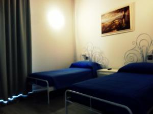 塔兰托B&B San Francesco的配有蓝色床单的客房内的两张床