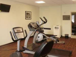 东叙拉古东锡拉丘兹司丽普套房酒店的一间健身房,在跑步机上配有电话