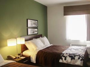 东叙拉古东锡拉丘兹司丽普套房酒店的酒店客房设有床和窗户。