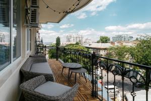 敖德萨Royal Flowers Apartments的阳台配有桌椅,享有城市美景。
