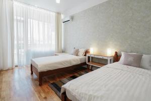 敖德萨Royal Flowers Apartments的酒店客房设有两张床和窗户。