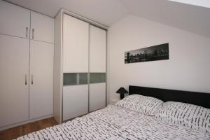萨格勒布Apartments Zagreb Schone的卧室配有白色橱柜和1张床。