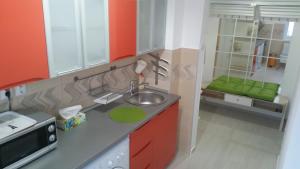 布加勒斯特Universitate Residence的厨房配有红色和白色的橱柜和水槽