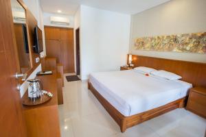 勒吉安Sinar Bali Hotel的酒店客房,配有床和电视