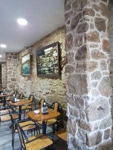 穆罗斯A Vianda的石墙餐厅设有木桌和椅子