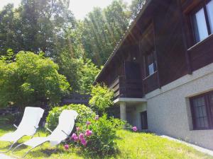 马里博尔Holiday Home Vesenjak的房子的院子内有两把白色的椅子