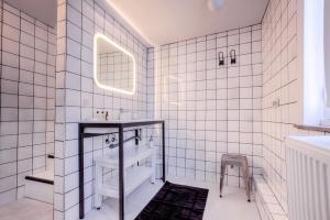 蒙斯Mons Dragon House的白色瓷砖浴室设有水槽和镜子