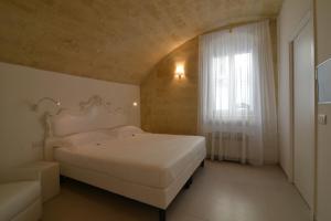 马泰拉Casa Blanca Matera的卧室配有白色的床和窗户。
