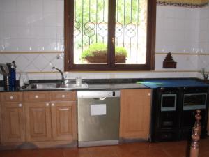 OjacastroCasa Rural Ugarte Ojacastro的厨房配有水槽、炉灶和窗户。