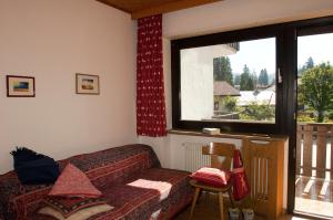 卡雷扎湖Casa al Lago di Carezza - Dolomiti的带沙发和窗户的客厅
