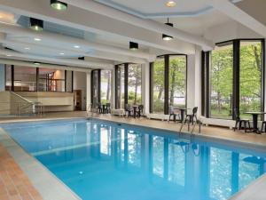 悉尼悉尼新斯科舍省旅程酒店的一个带椅子和窗户的大型游泳池