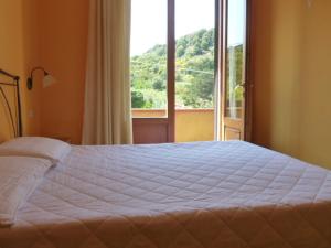 马尔恰纳Bed & Breakfast - Anselmi M&M的一间卧室设有一张大床和一个大窗户