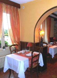 La Ferté-MacéAuberge d'Andaines的一间用餐室,配有2张带白色桌布的桌子