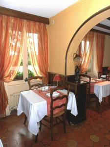 La Ferté-MacéAuberge d'Andaines的一间设有两张桌子和镜子的用餐室