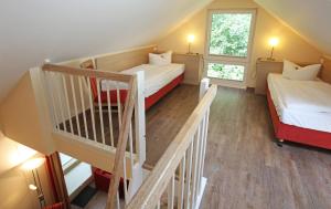 特拉森海德特拉森穆尔度假公寓的小房间设有两张床和楼梯