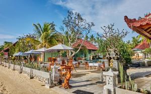 蓝梦岛斯库比都简易别墅假日公园的海滩上带桌子和遮阳伞的餐厅