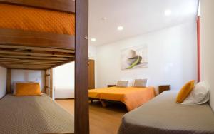 塞图巴尔Russo's Hostel的一间带两张床的卧室和一间带两张床的房间