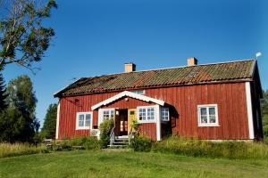 BoxholmPensionat Hogården的蓝色天空的田野中的红色谷仓