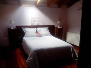 杜兰戈Dukebaso的卧室配有白色的床,上面装有粉红色的袋子