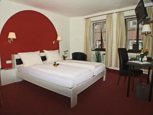 肯钦根贝勒酒店的一间卧室配有一张大床和红色床头板