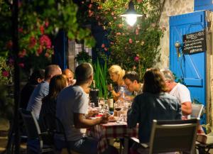 Port-Sainte-Marie拉洛奇尼尔住宿加早餐旅馆的一群坐在餐桌旁吃饭的人