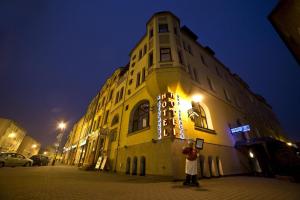 巴尔托希采巴提斯酒店的一个人晚上站在建筑物前