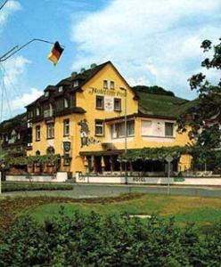 吕德斯海姆咖啡博斯特酒店的一座大型的黄色房子,风筝在空中飞行