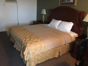 大西洋城日落汽车宾馆的酒店客房配有一张带白色枕头的大床