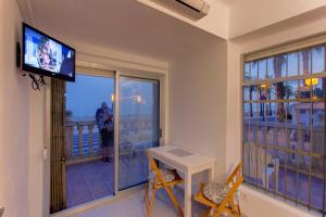 萨洛Apartamento Miramar的客房设有带电视和桌椅的阳台。