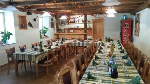 Knežak普里珀札茹农家乐的大型用餐室配有长桌和椅子