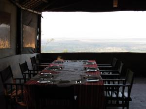 姆托瓦姆布African Sunrise Lodge and Campsite的一张长桌,房间带椅子和大窗户