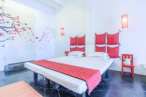 蓬蒂切里Itsy By Treebo - Red Lotus Heritage Promenade Beach的一间卧室配有一张带红色枕头的大床