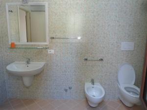 维耶斯泰Appartamento Bilocale a 200 m dalla spiaggia的一间带水槽、卫生间和镜子的浴室